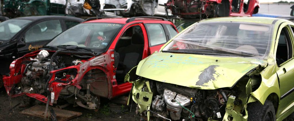 Junk cars sitting in wrecking yard after being removed and stripped for parts