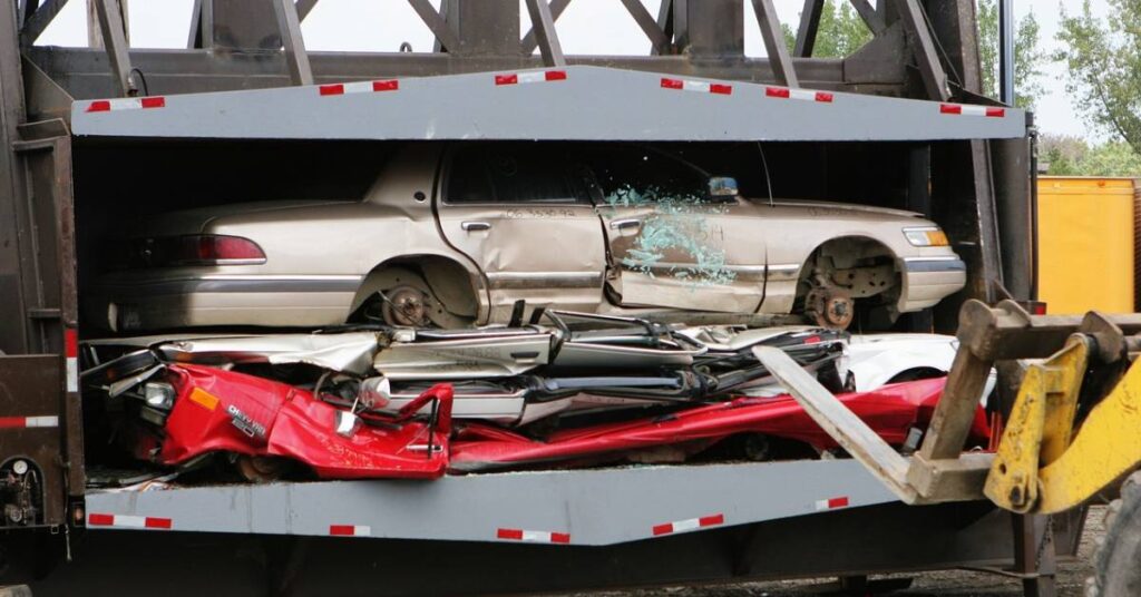 A scrap yard that is using a scrap press for recycling vehicles.