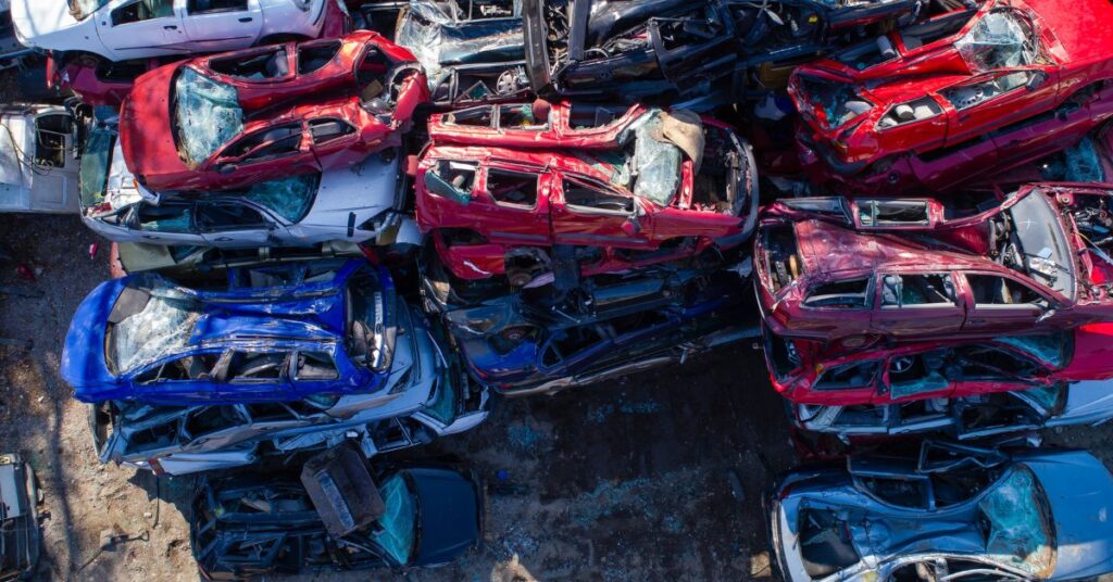 Several crushed cars in junkyard.