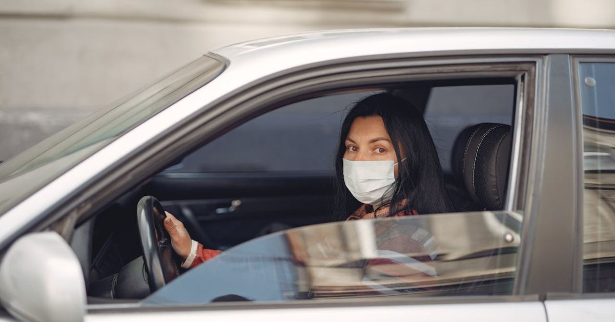 A girl driving a car while wearing face mask during COVID-19.