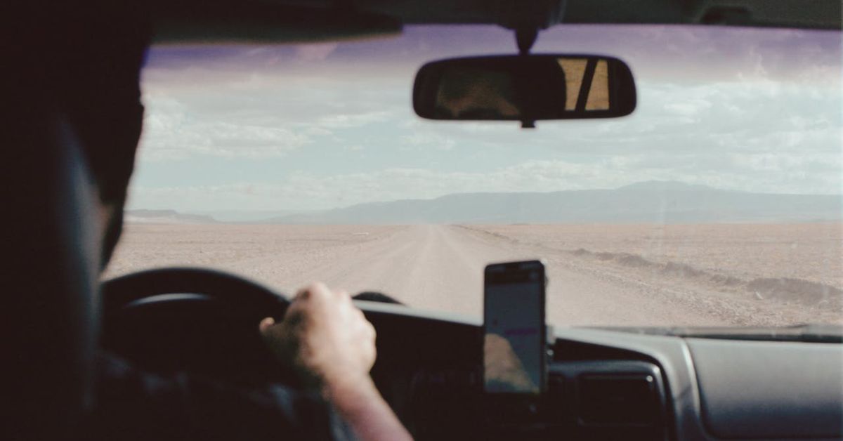 A man driving long distance alone in a car.
