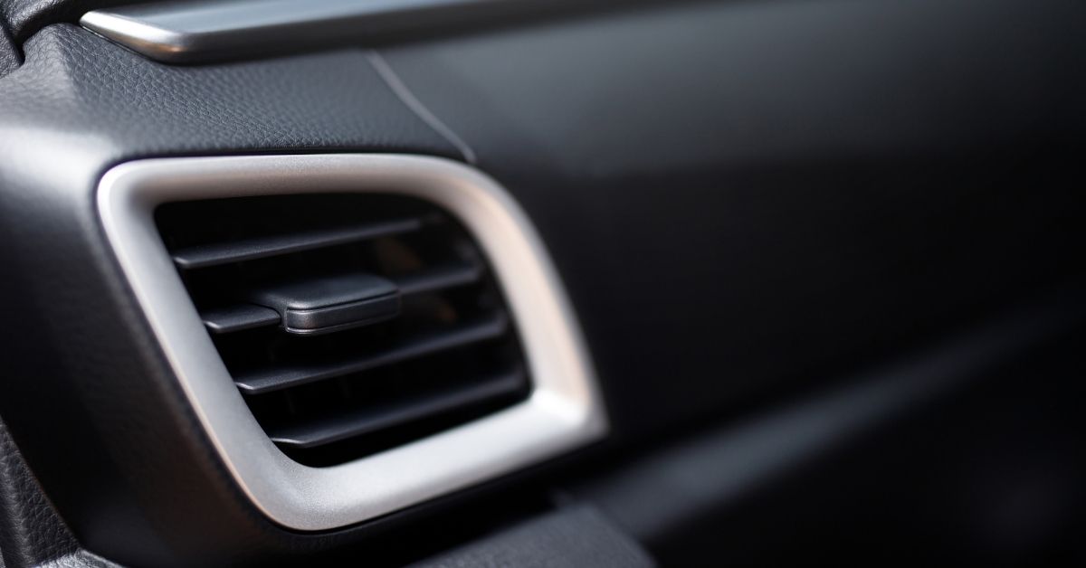 Close-up view of a car's air conditioning vent with a sleek black and silver design.
