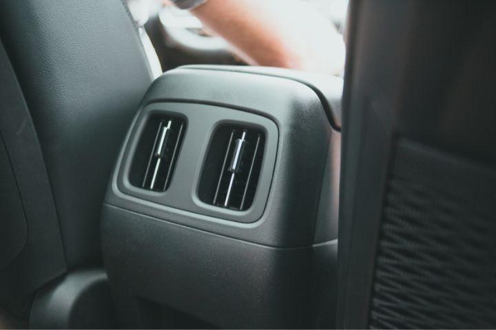 A close-up of rear seat air conditioning vents located on the back of a car’s center console.
